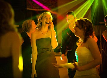 Celebrate: Guests dancing against disco strobe lighting effect backdrop.
